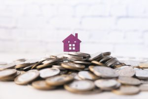 stack of coins and house on table the concept of